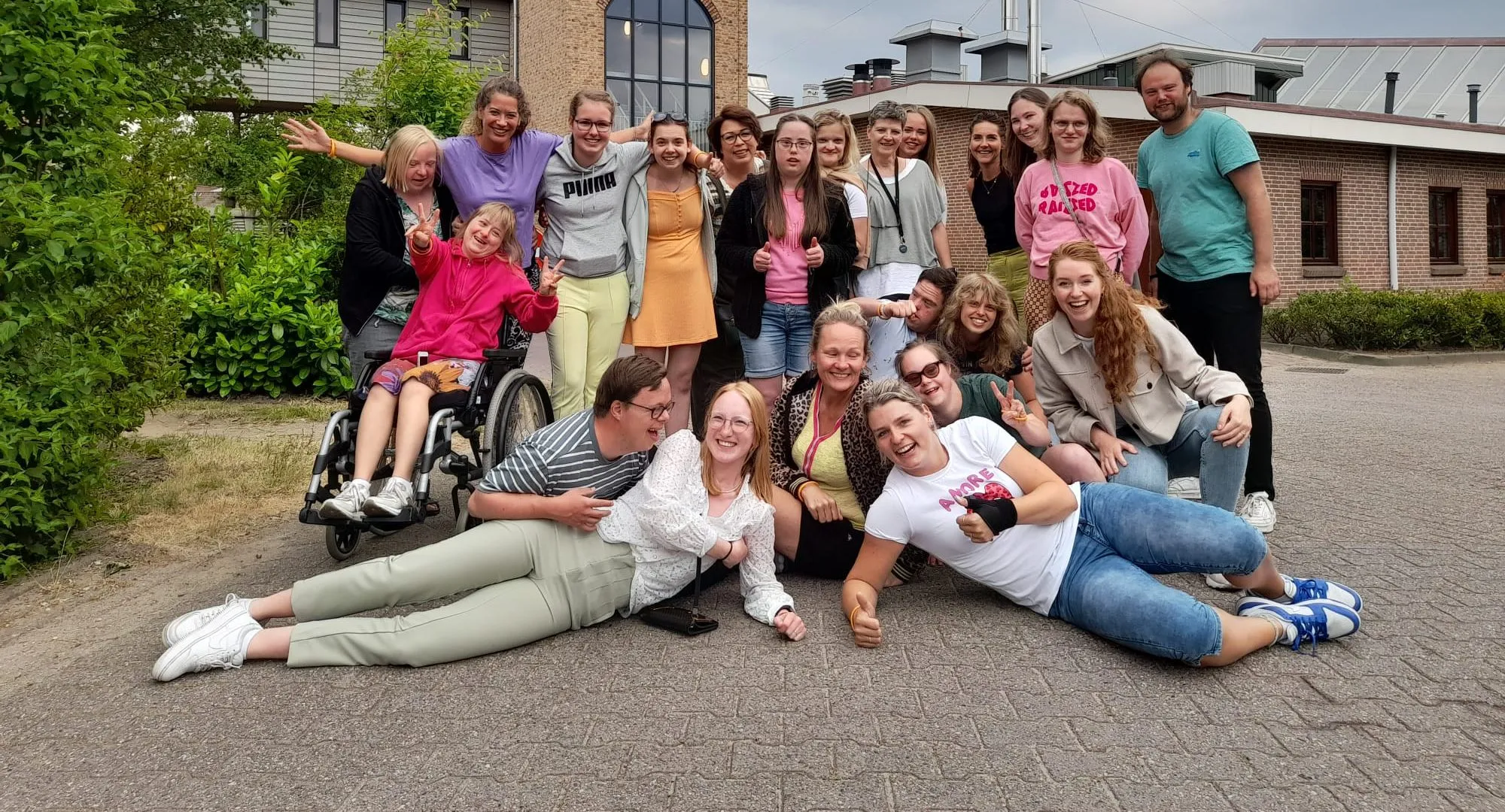 Bewoners en begeleiders van De Hooiberg samen op een groepsfoto buiten